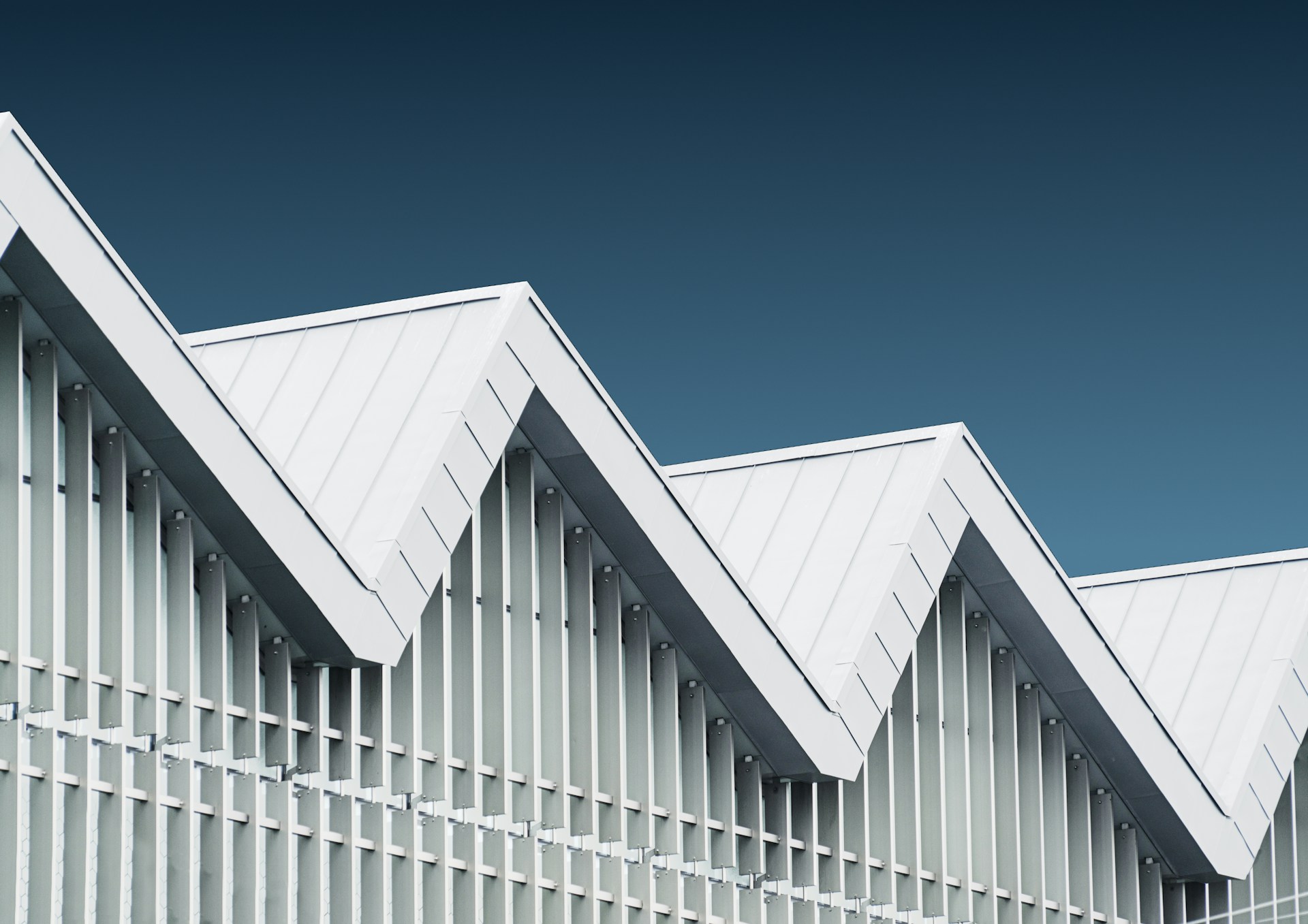 Commercial roofing — angular metal roof structure against blue sky